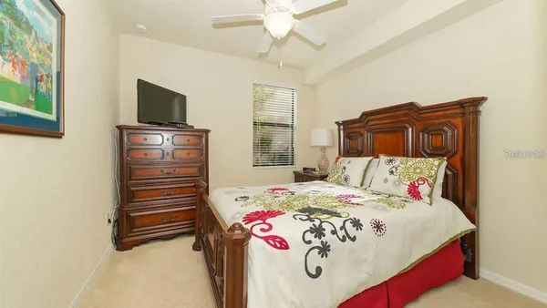 a bedroom with a bed dresser and flat screen tv