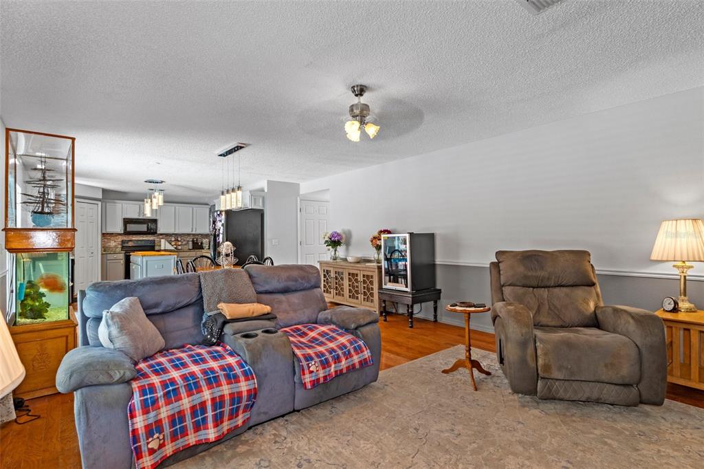 10331 Dunkirk Road Spring Hill, FL 34608 - Photo 23 of 42 a living room with furniture and a chandelier