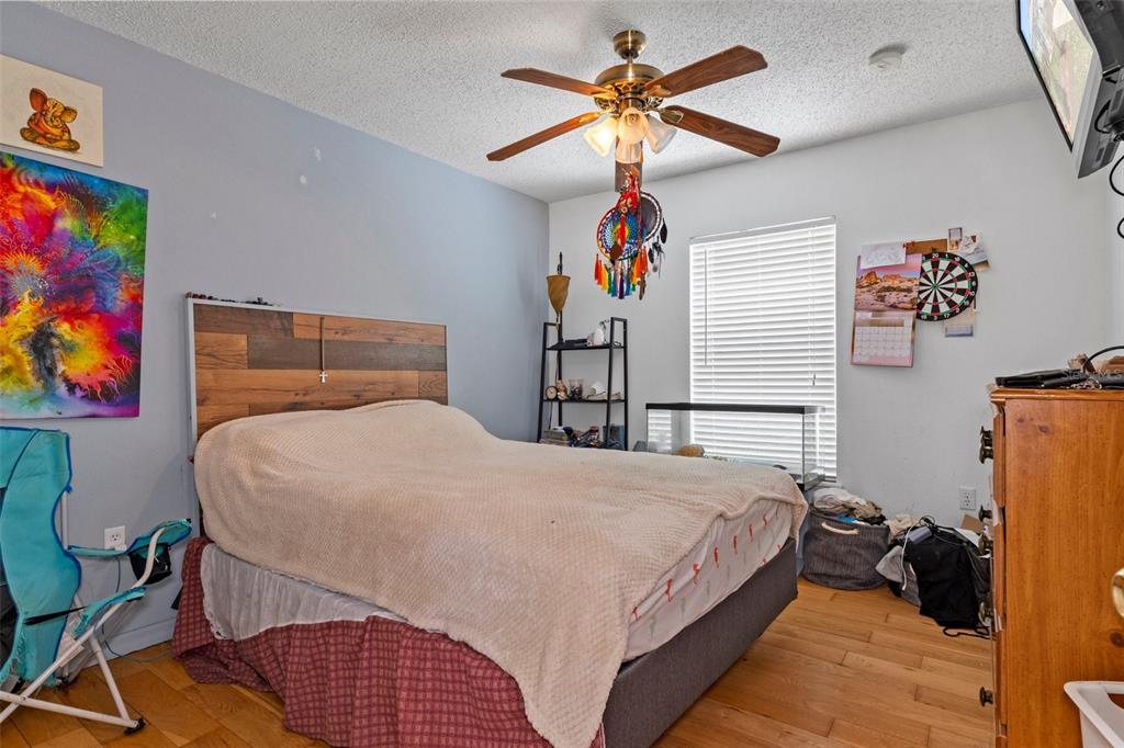 10331 Dunkirk Road Spring Hill, FL 34608 - Photo 28 of 42 a bedroom with a bed and a chandelier