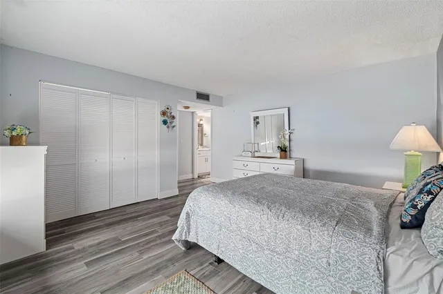 a bedroom with a bed and a refrigerator