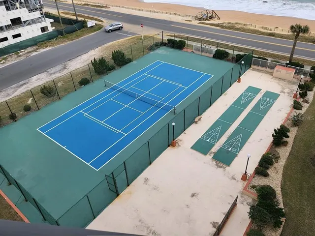 a view of a tennis ground with large windows