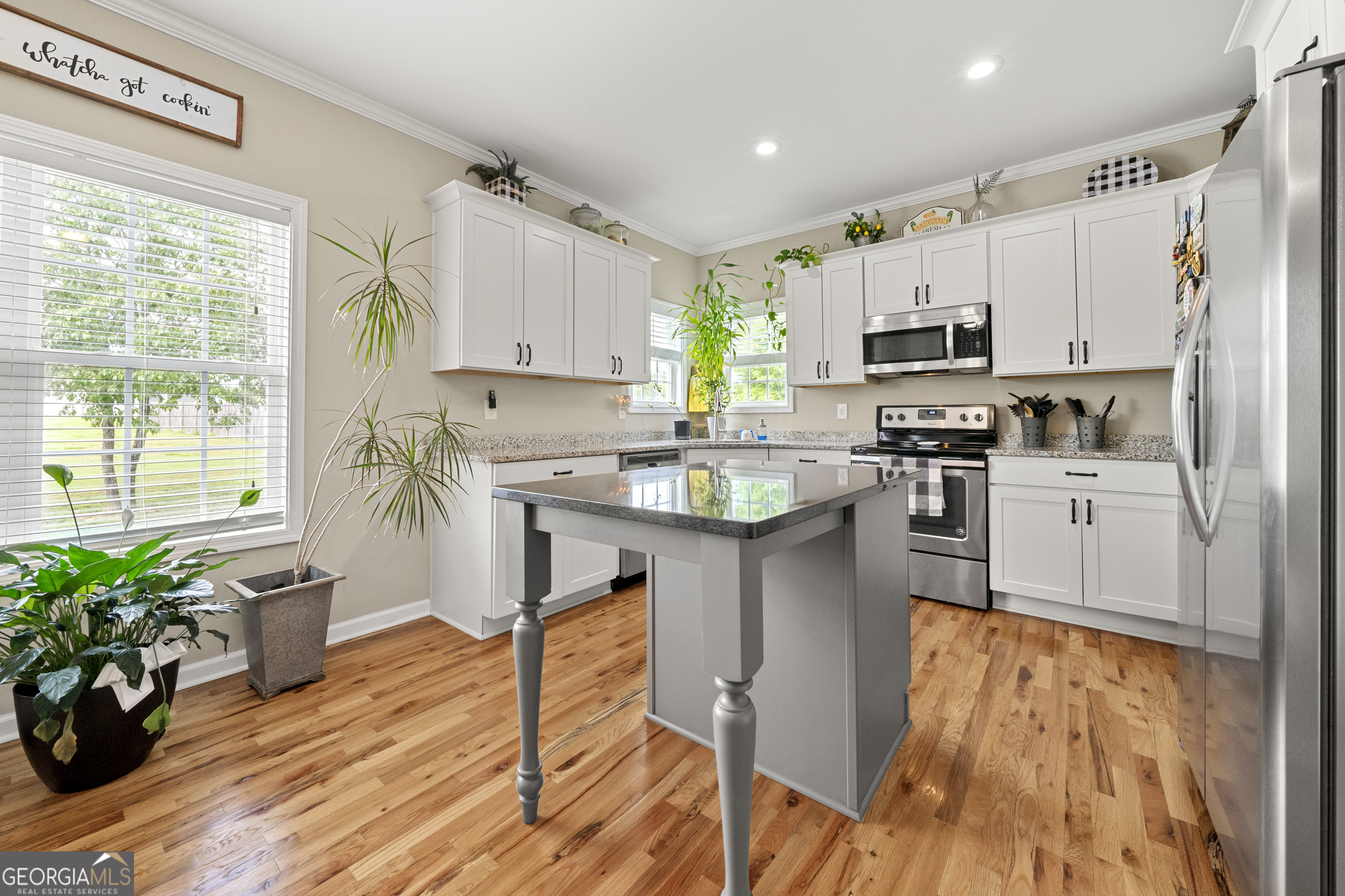 304 Kodiak Road Carrollton, GA 30117 - Photo 16 of 36 a kitchen with kitchen island granite countertop a sink cabinets and wooden floor