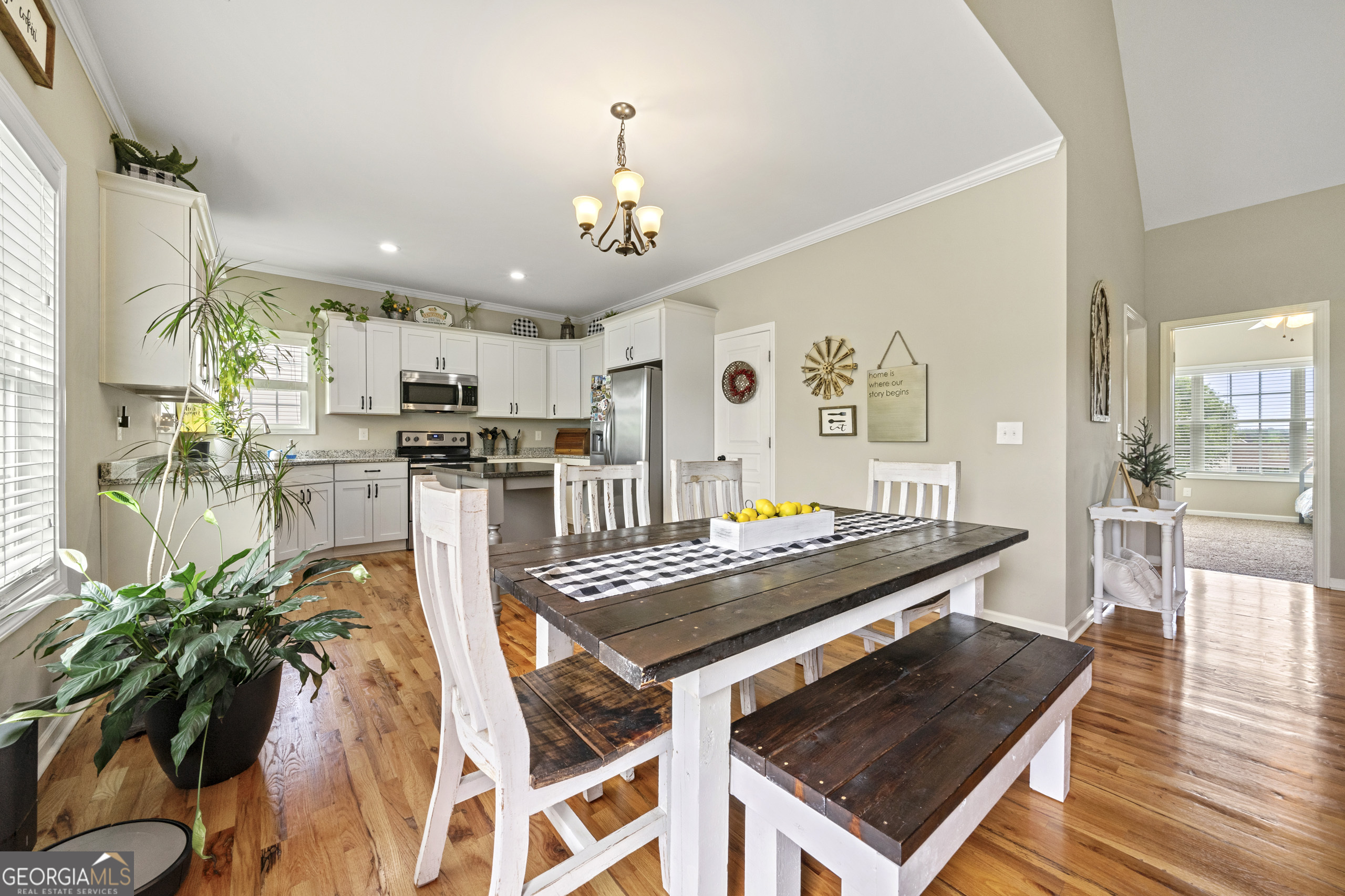 304 Kodiak Road Carrollton, GA 30117 - Photo 18 of 36 a kitchen with stainless steel appliances granite countertop a stove a refrigerator a oven a sink a dining table and chairs with wooden floor