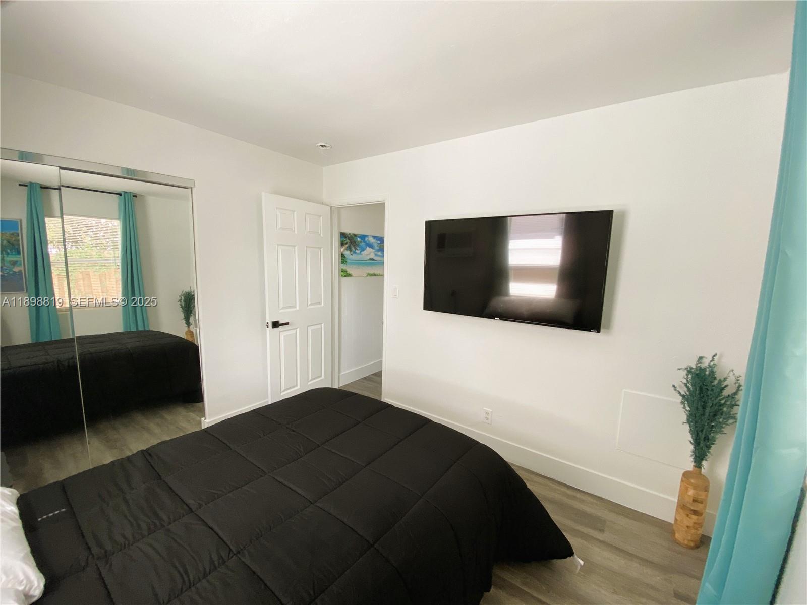 3208 Canal Drive, Unit 4 Pompano Beach, FL 33062 - Photo 2 of 15 a bedroom with a bed and a flat screen tv