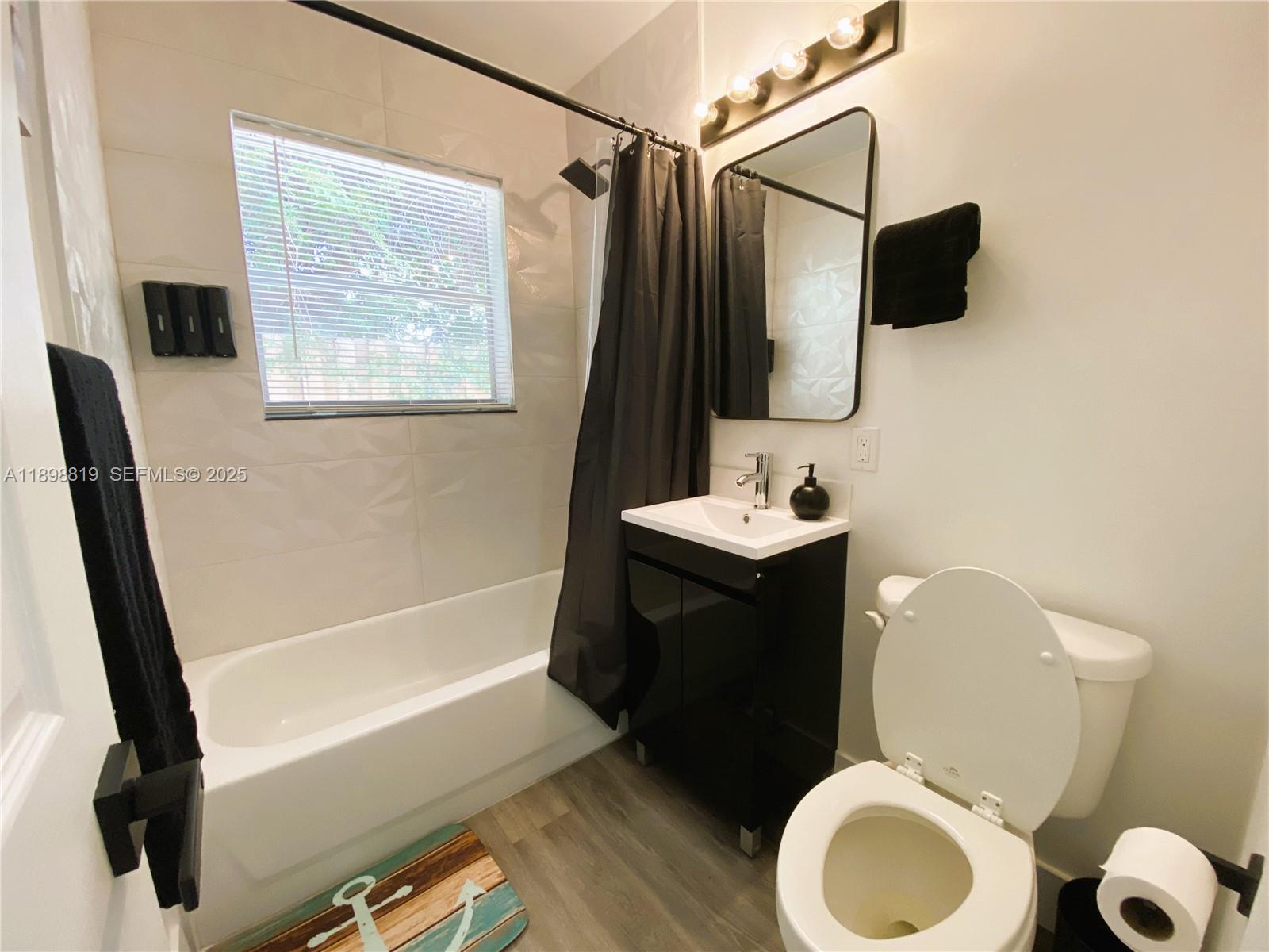 3208 Canal Drive, Unit 4 Pompano Beach, FL 33062 - Photo 8 of 15 a bathroom with a sink a toilet a vanity and bathtub