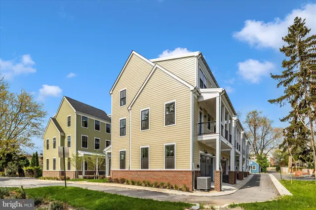 a view of a white house with a yard and plants