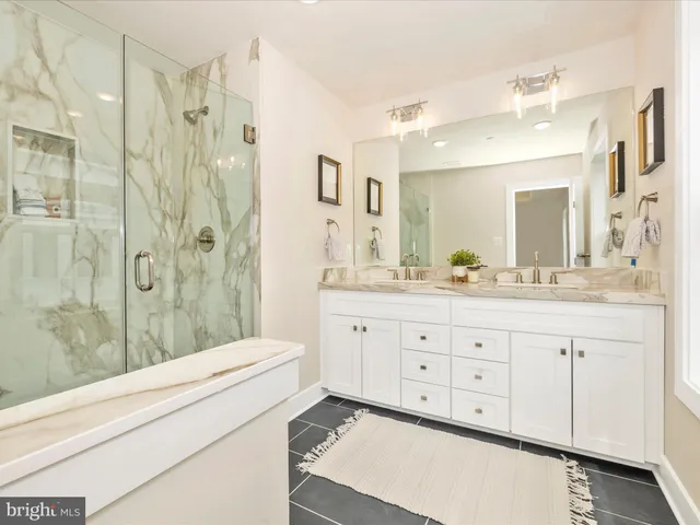 a bathroom with a granite countertop sink mirror and shower