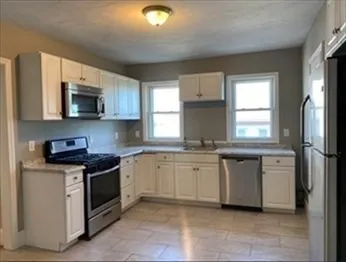 a kitchen with stainless steel appliances granite countertop a stove a sink and a microwave