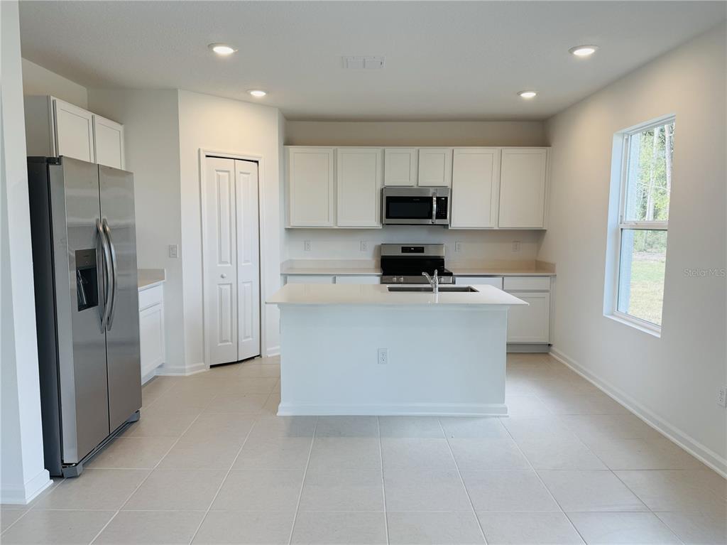 1386 Inkberry Circle DeLand, FL 32720 - Photo 2 of 16 a kitchen with white cabinets and refrigerator