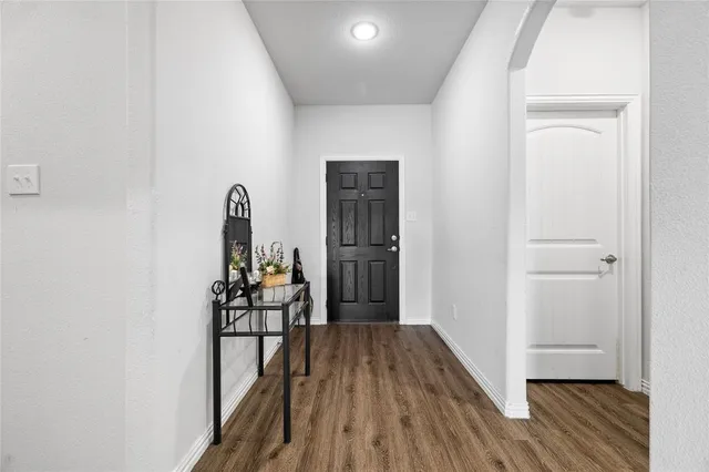 a view of a hallway with wooden floor and dining room
