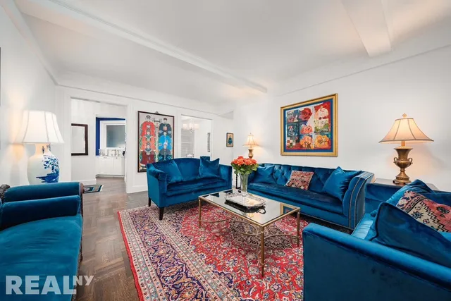 a living room with furniture a couch and paintings on the wall