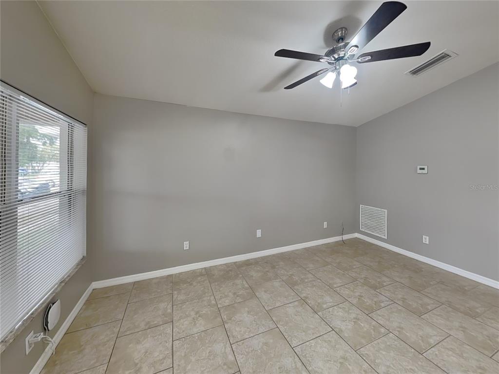 Undisclosed Address Port Orange, FL 32127 - Photo 3 of 16 an empty room with windows and fan
