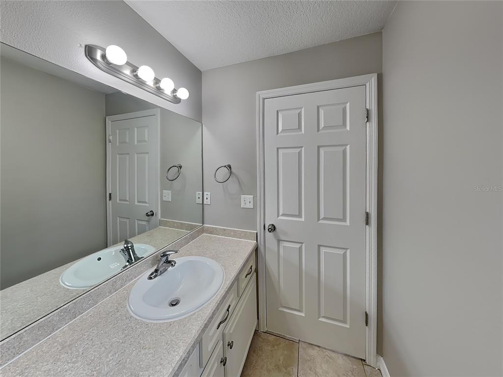 Undisclosed Address Port Orange, FL 32127 - Photo 9 of 16 a en suite bathroom with a double vanity sink a large mirror a shower and vanity