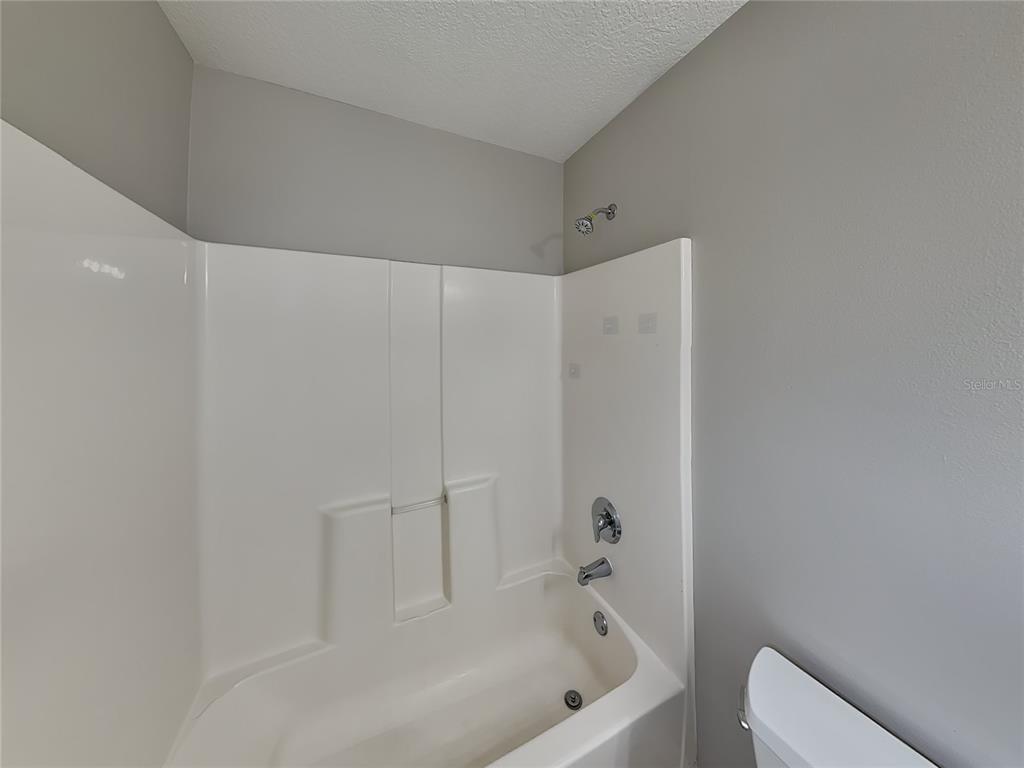 Undisclosed Address Port Orange, FL 32127 - Photo 10 of 16 a bathroom with a bathtub and shower