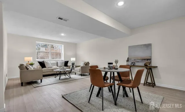 a living room with furniture a dining table and a window