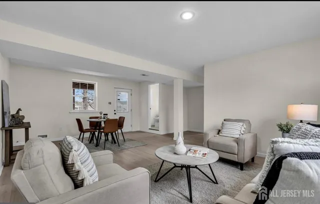 a living room with furniture and a dining table with garden view