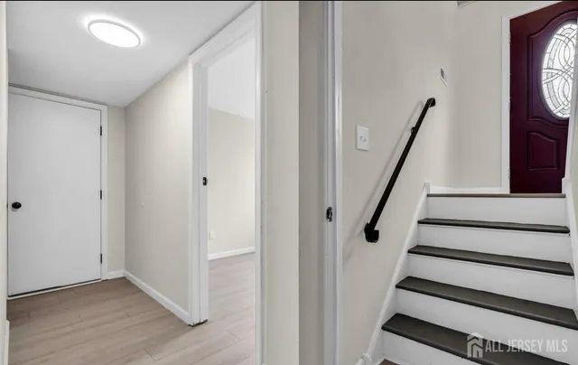 a view of staircase with wooden floor and white walls