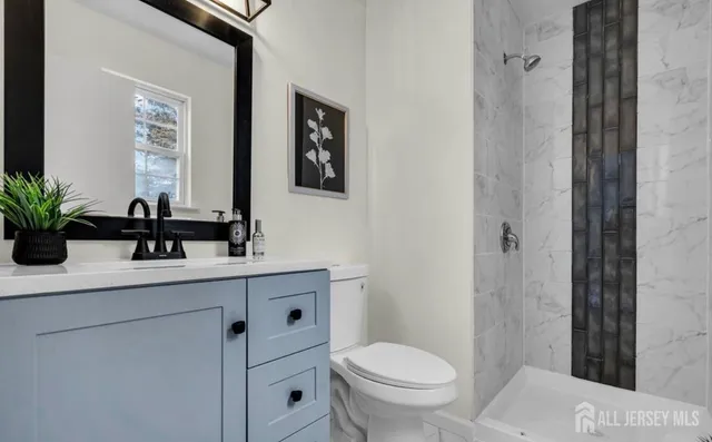 a bathroom with a sink a toilet a shower and a mirror