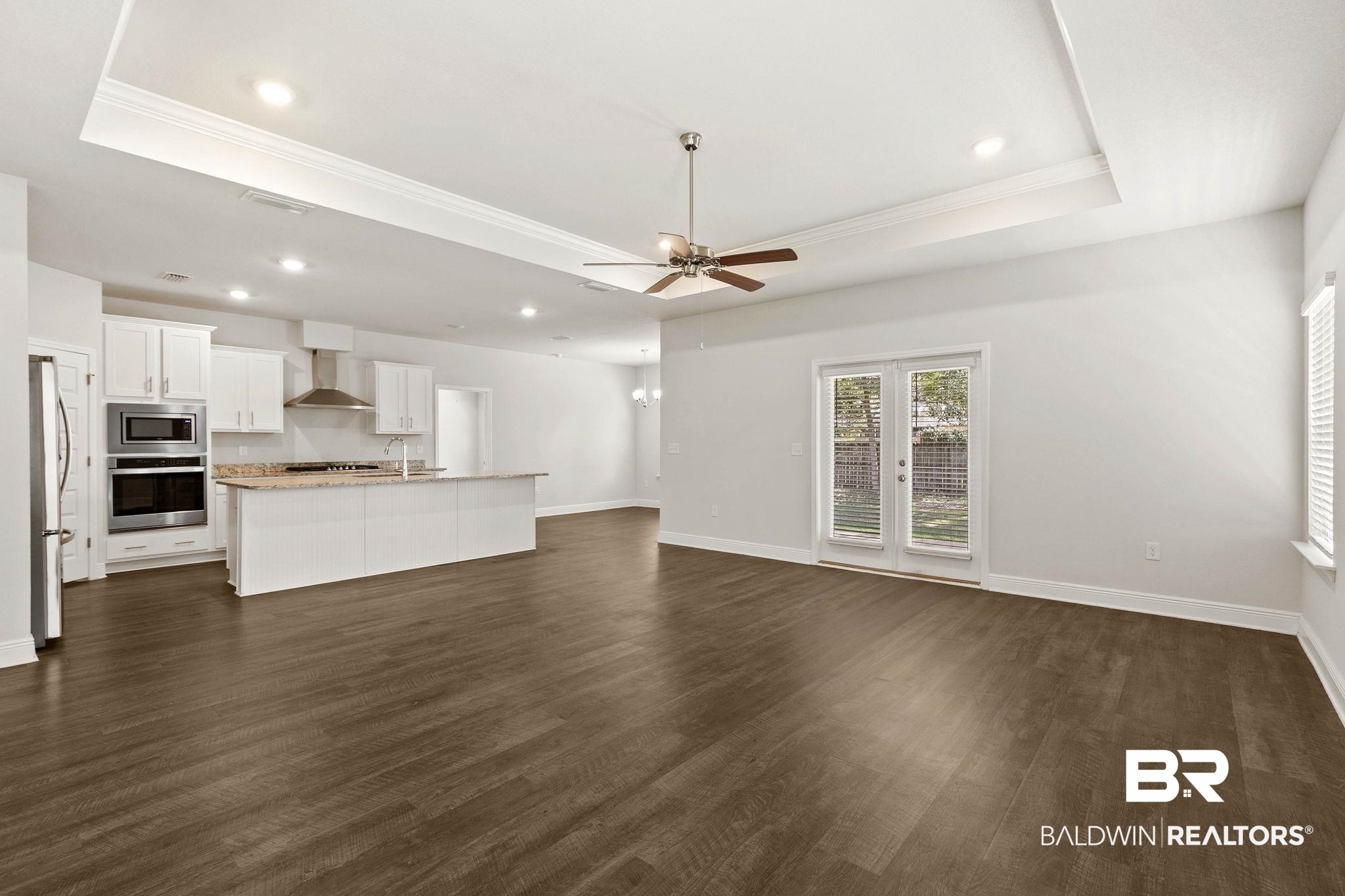 9448 Amethyst Drive Daphne, AL 36526 - Photo 12 of 61 Unfurnished living room featuring a ceiling fan, dark wood finished floors, crown molding, recessed lighting, and a raised ceiling