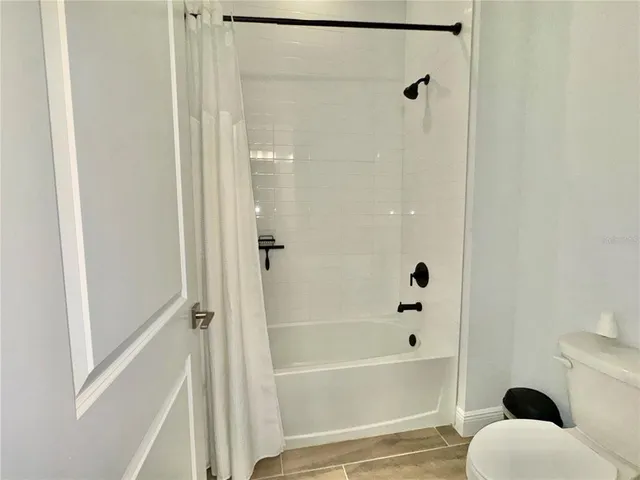 a living room with furniture kitchen view and a flat screen tv