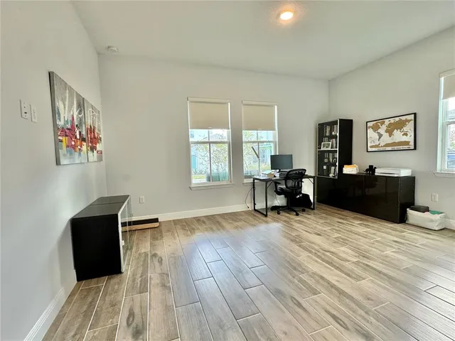 a view of a hallway with wooden floor and entryway