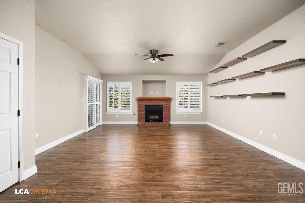 Undisclosed Address Bakersfield, CA 93312 - Photo 19 of 28 an empty room with wooden floor fireplace and windows