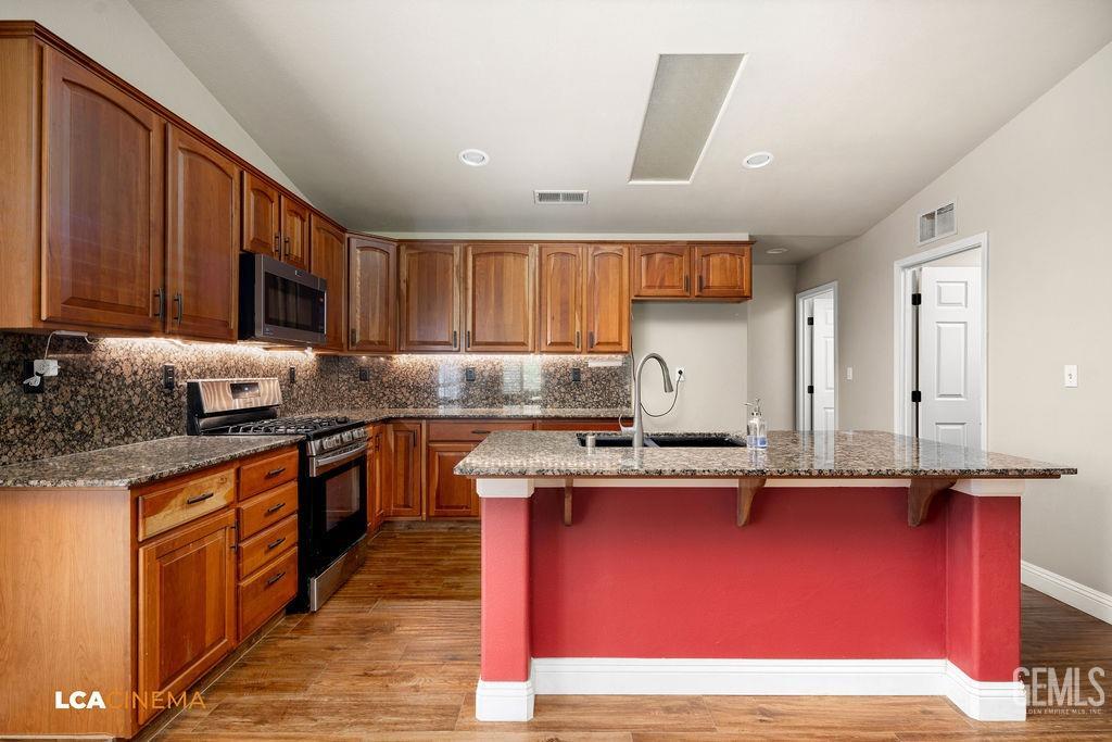 Undisclosed Address Bakersfield, CA 93312 - Photo 20 of 28 a kitchen with kitchen island granite countertop wooden cabinets and a sink