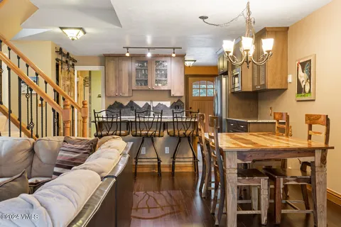 a living room with furniture a chandelier and a dining table