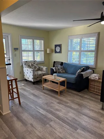 a living room with furniture wooden floor and a window