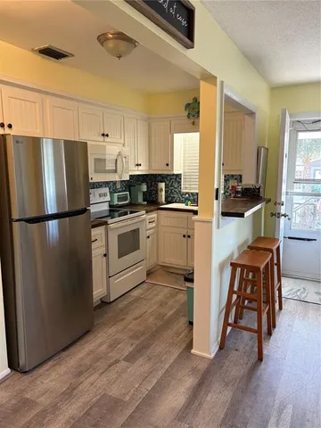 a kitchen with wooden floors and stainless steel appliances