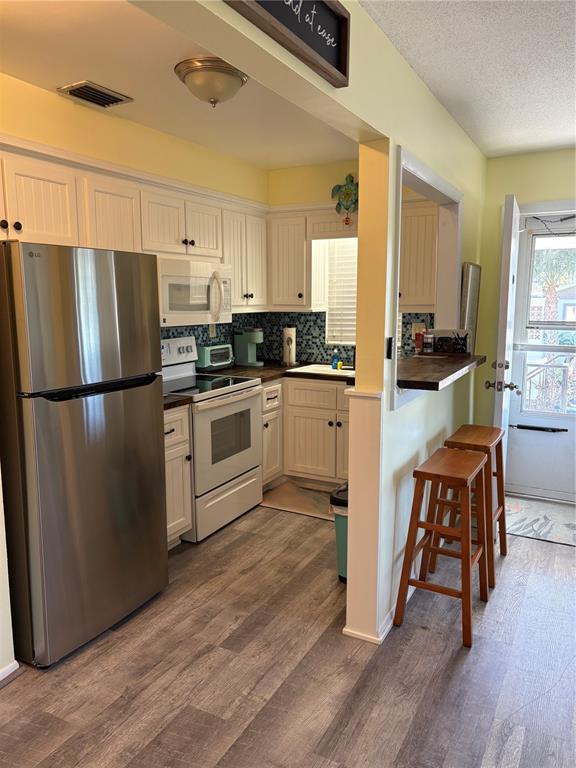 14531 Walsingham Road, Unit 225 Largo, FL 33774 - Photo 10 of 17 a kitchen with wooden floors and stainless steel appliances