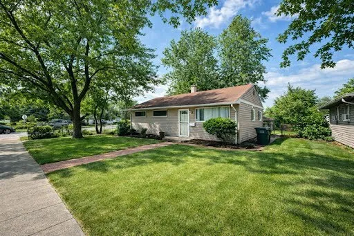 a view of a house with backyard and sitting area
