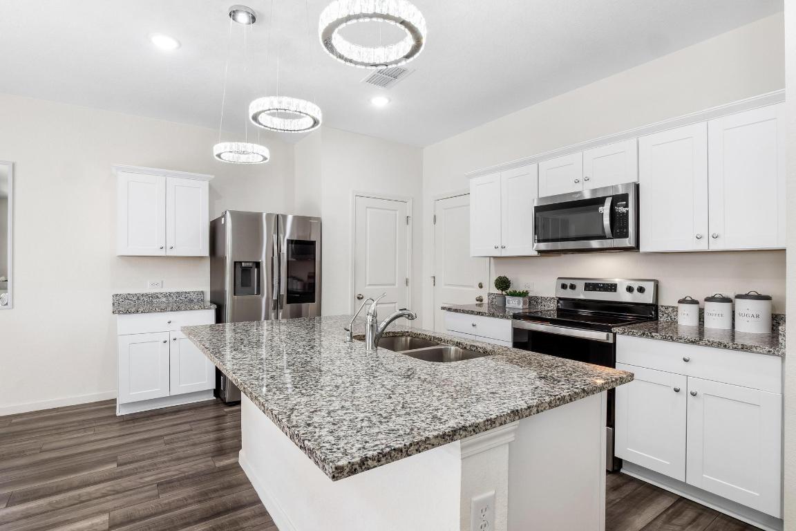 101 Magnum Force Drive Jarrell, TX 76537 - Photo 12 of 29 a kitchen with stainless steel appliances granite countertop a sink stove and refrigerator