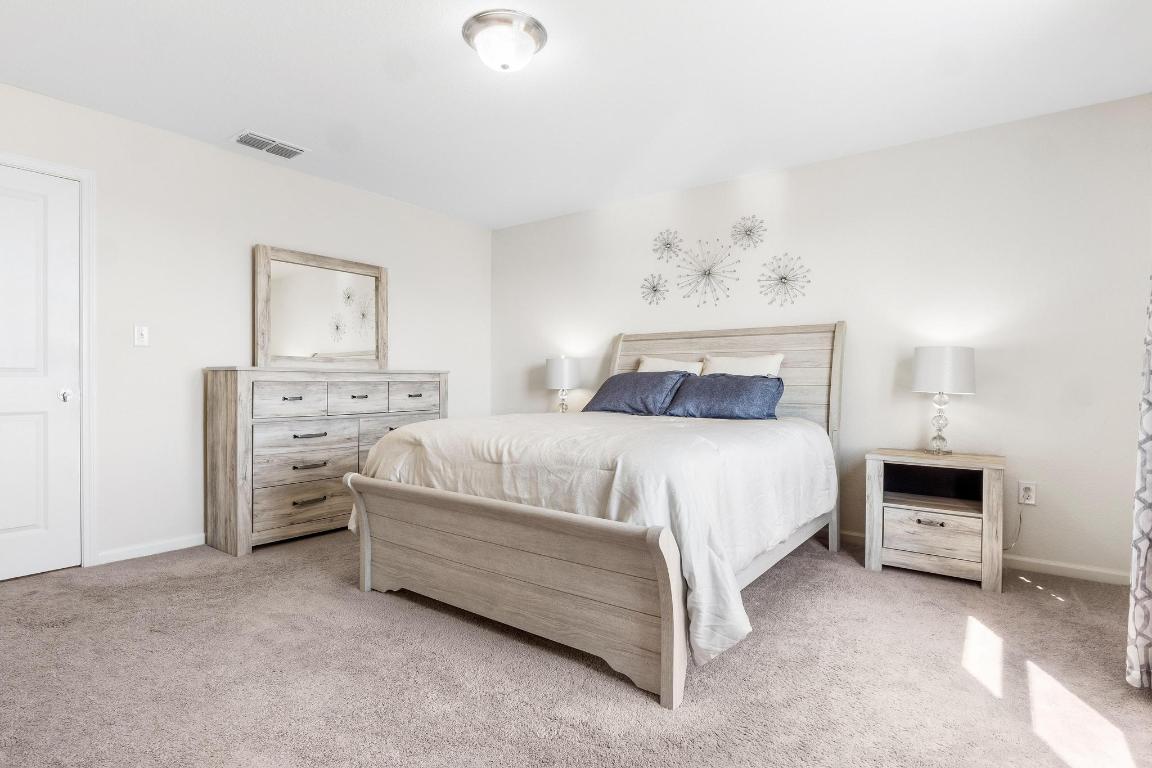 101 Magnum Force Drive Jarrell, TX 76537 - Photo 18 of 29 a bedroom with a bed and a lamp on dresser