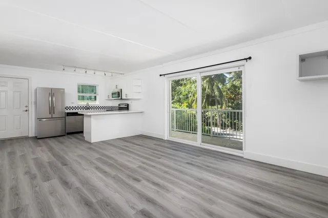 a kitchen with stainless steel appliances granite countertop a stove top oven a sink with wooden floors and cabinets