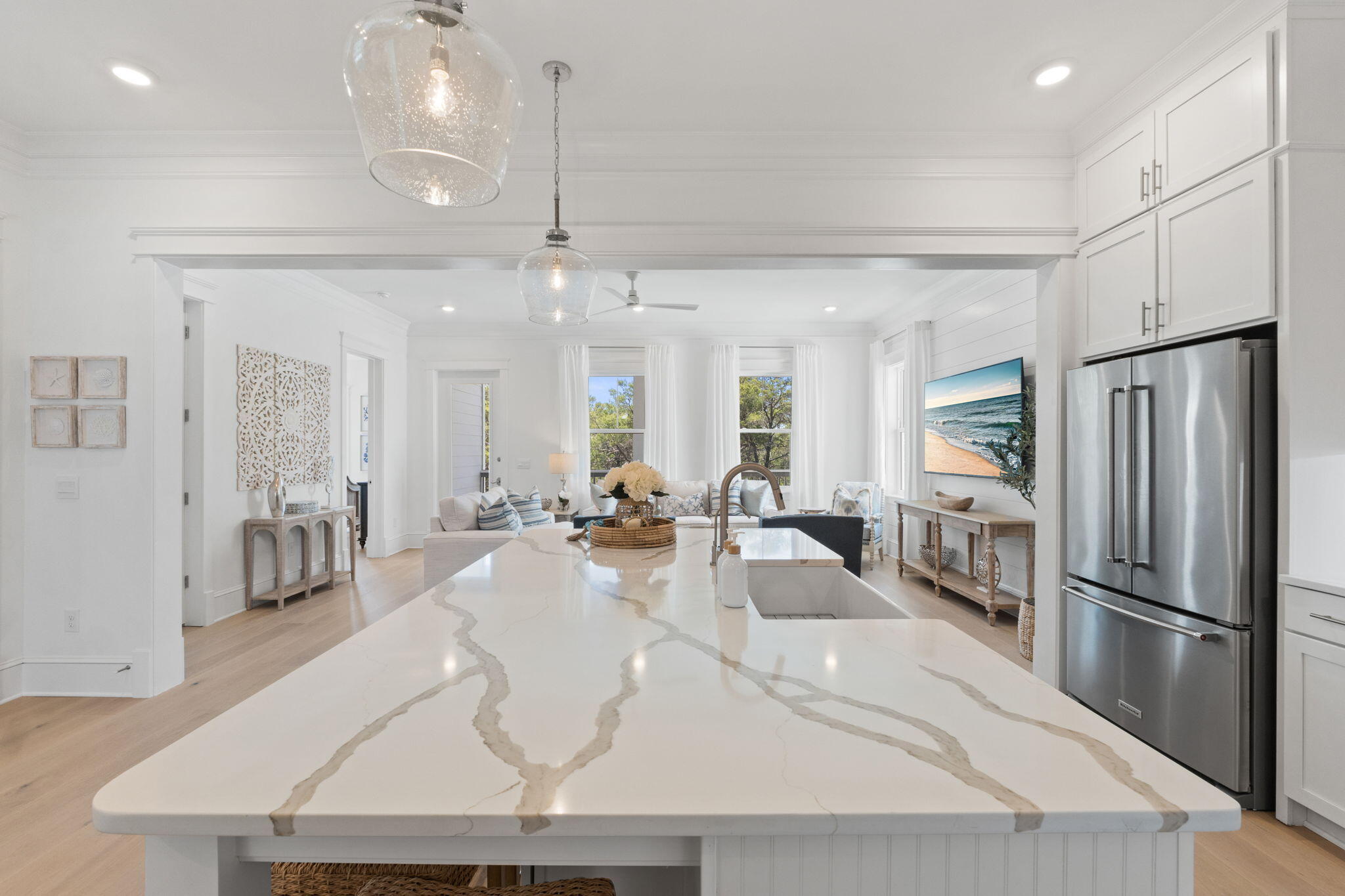 80 Seaboard Lane Santa Rosa Beach, FL 32459 - Photo 13 of 88 a large kitchen with a refrigerator a sink dishwasher a dining table and chairs with wooden floor
