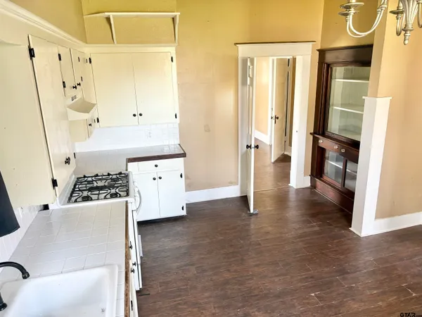 a kitchen with granite countertop a sink a stove and cabinets