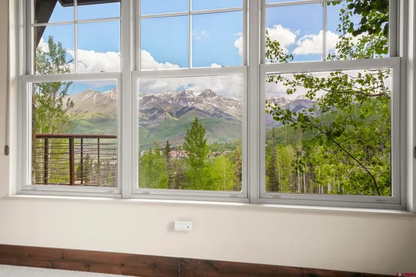 a bedroom with a bed couch and a large window