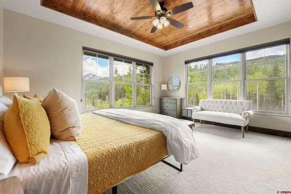 a spacious bedroom with a bed and a flat screen tv