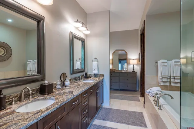 a en suite bathroom with a granite countertop sink and a mirror