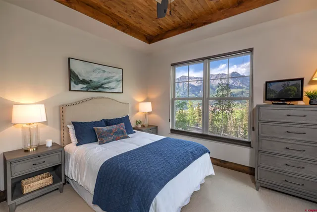 a bedroom with a bed and a flat tv screen on dresser