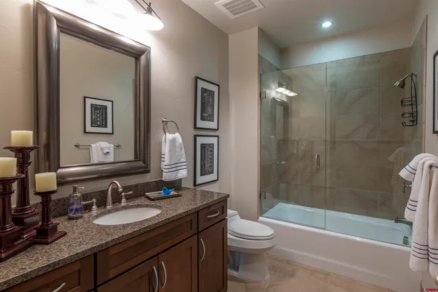 a bathroom with a granite countertop sink toilet and shower