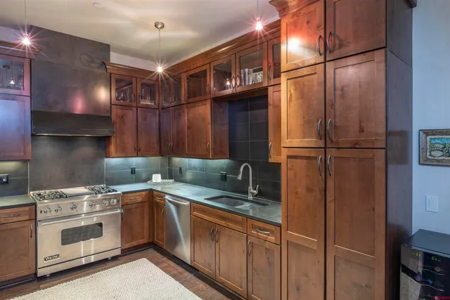 a kitchen with stainless steel appliances granite countertop a sink stove and cabinets