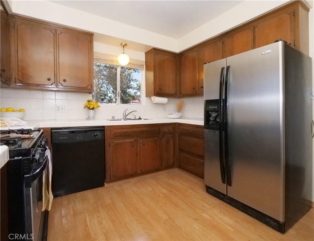 156 Vía Los Altos Redondo Beach, CA 90277 - Photo 12 of 25 a kitchen with stainless steel appliances a refrigerator a sink a stove a microwave and island
