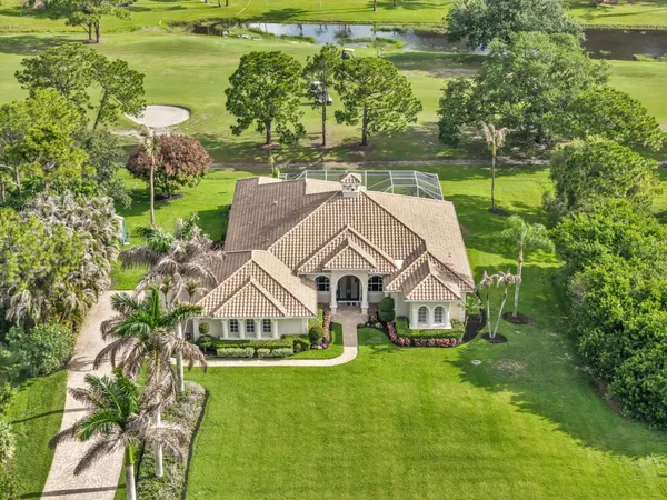 a view of a lake with a yard and large trees
