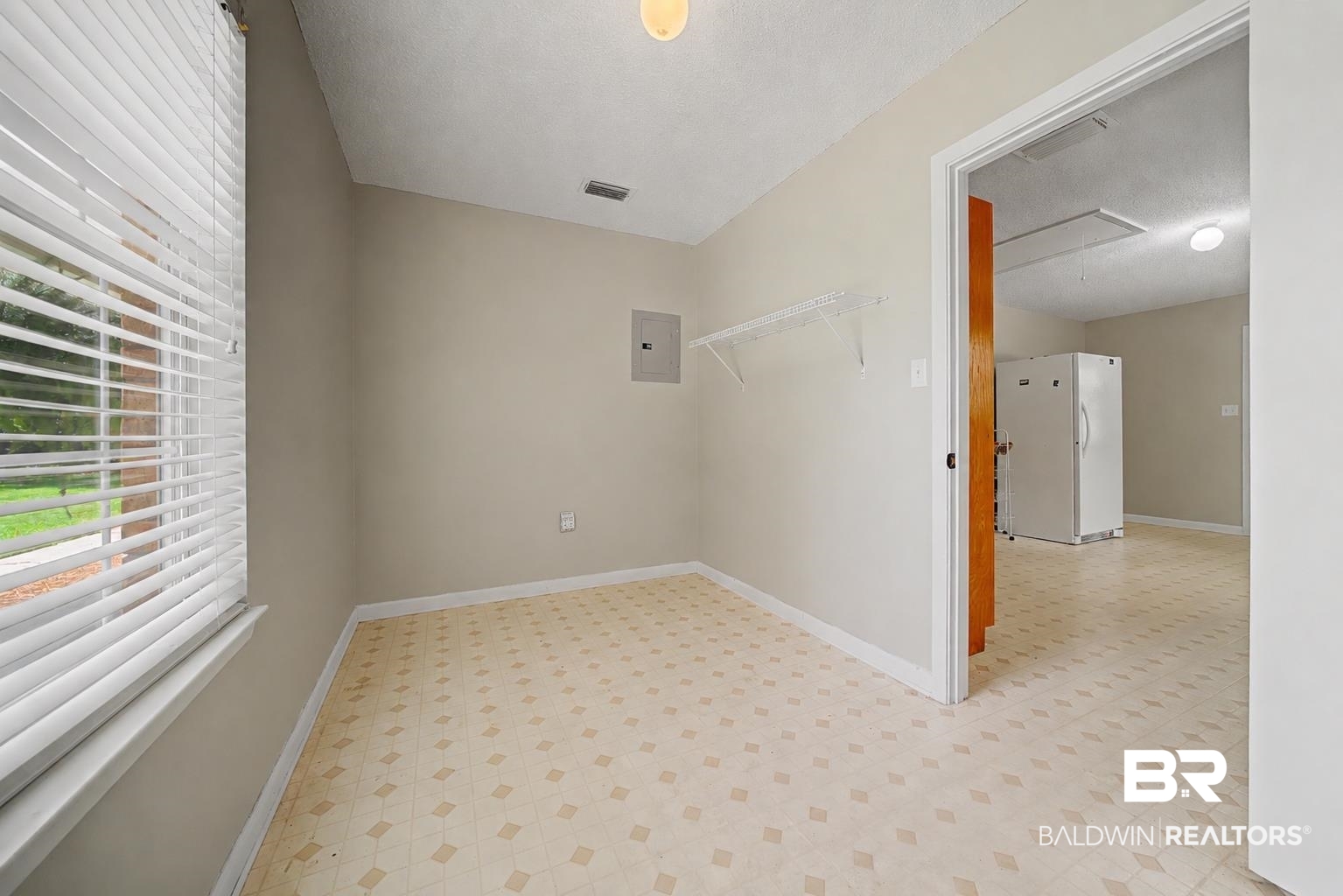 22963 Highway 98 Foley, AL 36535 - Photo 34 of 52 Neutral wall paint with patterned resilient flooring, window with blinds, and built-in wire shelving