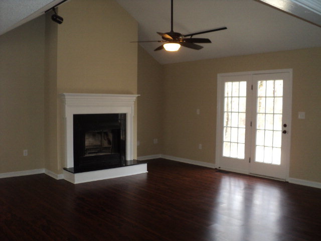 169 Pea Ridge Road Juliette, GA 31046 - Photo 3 of 12 an empty room with wooden floor fireplace and windows