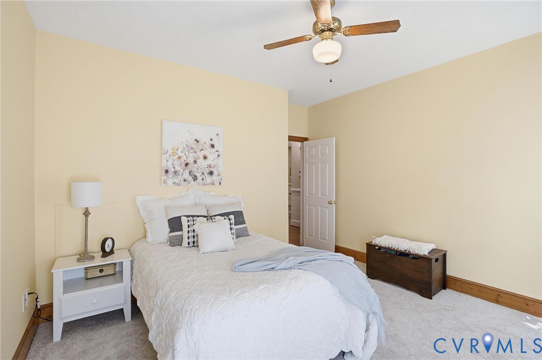 12123 Deer Ridge Court Ashland, VA 23005 - Photo 27 of 63 a bedroom with a bed and a chandelier