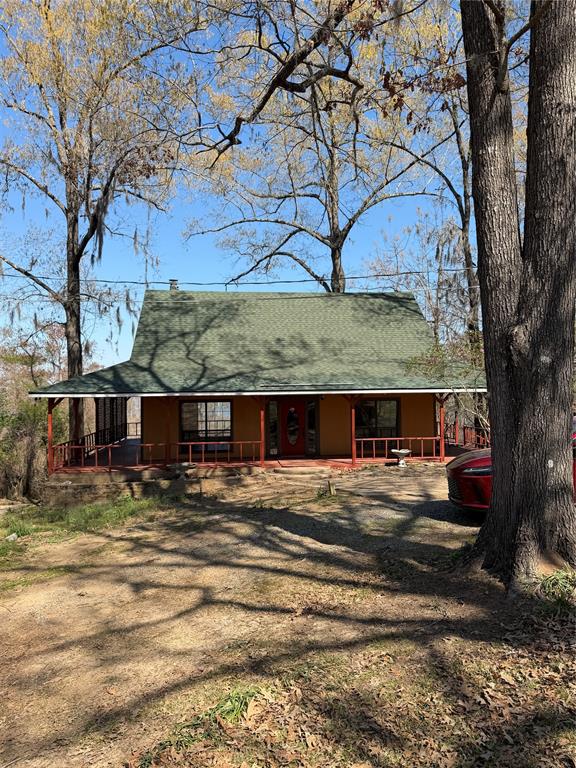 View of front of house featuring a porch and roof with shingles