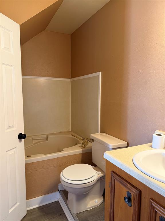 263 Highway 154 Ringgold, LA 71068 - Photo 15 of 38 Full bathroom featuring a garden tub, vanity, a textured wall, and dark wood-type flooring